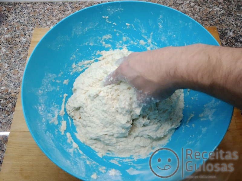 Amassar e juntar a água morna à farinha